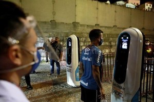 ELLITORAL_315511 |  Reuters Foto del miércoles del futbolista de Gremio Matheus Henriquepasando por un control de temperatura antes de un partido con Inter por el torneo Gaucho.