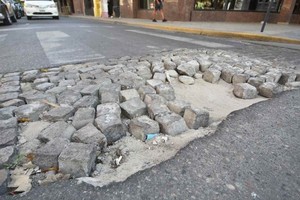 Manuel Fabatía San Martín esquina Corrientes. Un bache cubierto, en gran parte, por adoquines.