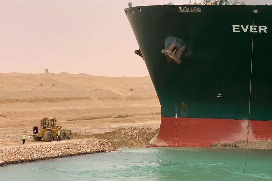 ELLITORAL_365270 |  Gentileza A handout picture released by the Suez Canal Authority on March 24, 2021 shows a part of the Taiwan-owned MV Ever Given (Evergreen), a 400-metre- (1,300-foot-)long and 59-metre wide vessel, lodged sideways and impeding all traffic across the waterway of Egypt's Suez Canal. - A giant container ship ran aground in the Suez Canal after a gust of wind blew it off course, the vessel's operator said on March 24, 2021, bringing marine traffic to a halt along one of the world's busiest trade routes. (Photo by - / Suez CANAL / AFP) / “The erroneous mention[s] appearing in the metadata of this photo by Marina PASSOS has been modified in AFP systems in the following manner: [STR] instead of [Marina Passos]. Please immediately remove the erroneous mention[s] from all your online services and delete it (them) from your servers. If you have been authorized by AFP to distribute it (them) to third parties, please ensure that the same actions are carried out by them. Failure to promptly comply with these instructions will entail liability on your part for any continued or post notification usage. Therefore we thank you very much for all your attention and prompt action