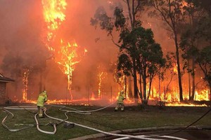 ELLITORAL_276623 |  Agencias This handout photo released by Fire & Rescue NSW on April 16, 2018 shows firemen tackling a bush fire in Holdsworthy, south of Sydney on April 15, 2018. 
Hundreds of firefighters were battling a large bushfire that burnt near Sydney homes, with authorities saying it was "miraculous" no homes were damaged and no-one was injured. / AFP PHOTO / Fire & Rescue NSW / FIRE & RESCUE NSW