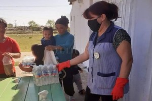 Gentileza María Inés Cano, de la iglesia Eben Ezer, entregando agua mineral a vecinas del barrio Las Vegas.