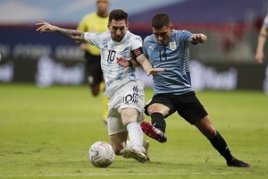 ELLITORAL_384775 |  Reuters Lionel Messi se lleva la pelota ante la marca uruguaya. El  10  está  enchufado  en esta Copa, jugó un gran partido ante los uruguayos, fue figura y autor de un golazo de tiro libre ante los chilenos y antes de empezar el torneo dijo que  estamos preparados para dar el golpe .