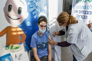 ELLITORAL_353971 |  JACK GUEZ Tomer, an 18-year-old teenager, receives a dose of the Pfizer-BioNtech COVID-19 coronavirus vaccine at Clalit Health Services, in Israel's Mediterranean coastal city of Tel Aviv on January 23, 2021. - Israel began administering novel coronavirus vaccines to teenagers as it pushed ahead with its inoculation drive, with a quarter of the population now vaccinated, health officials said. (Photo by JACK GUEZ / AFP)