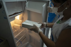 ELLITORAL_379926 |  Xinhua/Martín Zabala (210304) -- LA PLATA, 4 marzo, 2021 (Xinhua) -- Imagen del 3 de marzo de 2021 de una empleada del Ministerio de Salud de la Provincia de Buenos Aires guardando en un refrigerador cajas con dosis de vacunas desarrolladas por la farmacéutica china Sinopharm contra la enfermedad del nuevo coronavirus (COVID-19), en un centro de vacunación instalado en el Hipódromo de la ciudad de La Plata, Argentina. Argentina alista la aplicación de la vacuna desarrollada por la farmacéutica china Sinopharm contra la COVID-19, con la distribución en una primera etapa de 492 mil dosis, que estarán destinadas a inmunizar al personal docente de todas las jurisdicciones educativas del país. (Xinhua/Martín Zabala) (mz) (ah) (da) (vf) (dp)