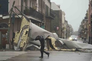 ELLITORAL_400391 |  Eric Gay Un hombre camina frente a la parte de un techo que fue arrancado de un edificio por los vientos del huracÃ¡n Ida, el domingo 29 de agosto de 2021, en Nueva Orleans. (AP Foto/Eric Gay)