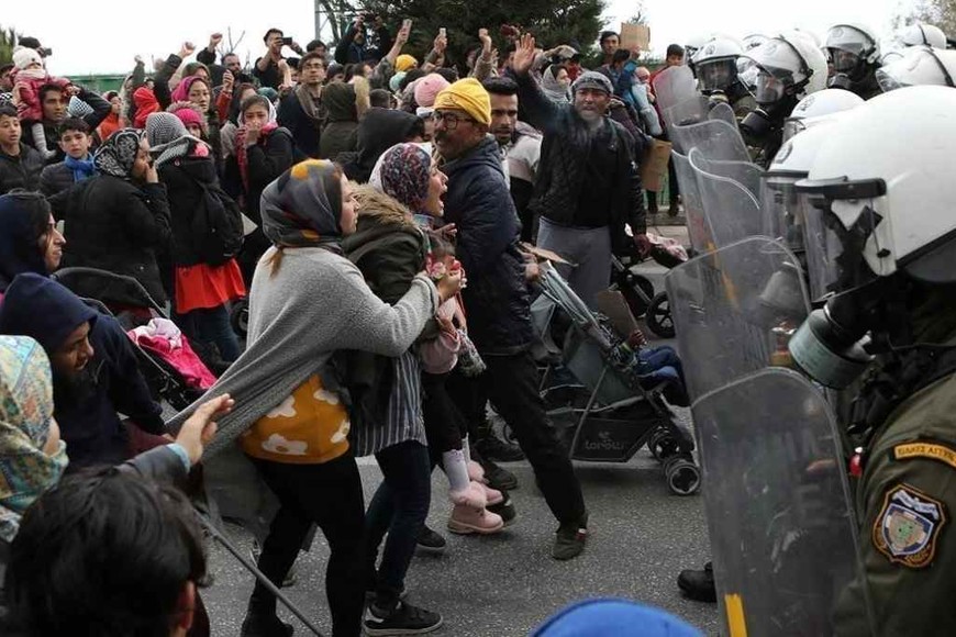 ELLITORAL_325049 |  Gentileza Mujeres, hombres y niños se enfrentan a las fuerzas policiales locales, en su intento por abandonar el campo de refugiados de Moria, Grecia. Las autoridades griegas insisten en que ellos mismos quemaron el campamento, para poder irse de allí.