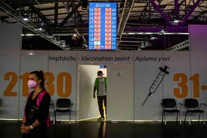 Imagen ilustrativa A worker peers out of a door in front of COVID-19 vaccination booths at the Arena Treptow vaccination centre in Berlin, Germany, August 9, 2021. Picture taken August 9, 2021. John Macdougall/Pool via REUTERS