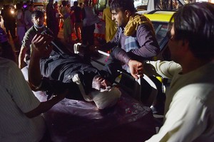 ELLITORAL_399718 |  WAKIL KOHSAR El personal médico y hospitalario lleva a un hombre herido en una camilla para recibir tratamiento después de dos explosiones, en las que murieron al menos cinco e hirió a una docena, frente al aeropuerto de Kabul el 26 de agosto de 2021 (Foto de Wakil KOHSAR / AFP).