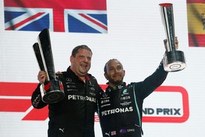 ELLITORAL_419610 |  Reuters Lewis Hamilton de Mercedes celebra en el podio con el trofeo después de ganar la carrera con un miembro del equipo