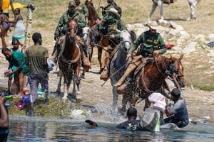 ELLITORAL_406197 |  Gentileza El servicio de vigilancia fronteriza de Texas utiliza sus riendas a modo de látigo contra los inmigrantes haitianos ilegales que intentan refugiarse en Estados Unidos.