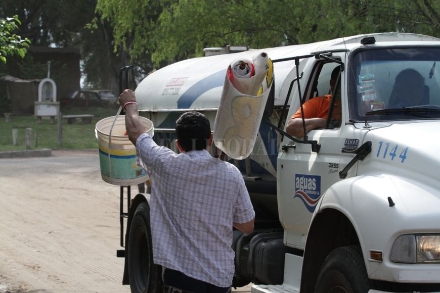 ELLITORAL_404652 |  Mauricio Garín Agua. Un vecino le pide abastecimiento de agua potable al camión que recorre el barrio para brindar el servicio.