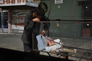 ELLITORAL_409904 |  Manuel Fabatía El hambre que más duele. Un joven revolviendo una bolsa de residuos en busca de comida.