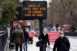 ELLITORAL_411711 |  Imagen ilustrativa Pedestrians, some wearing a face mask or covering due to the COVID-19 pandemic, walk past a sign alerting people that "COVID-19 cases are very high in London - Stay at Home", in central London on December 23, 2020. - Britain's public health service urged Prime Minister Boris Johnson on Wednesday to extend the country's Brexit transition period or risk pushing hospitals already struggling with coronavirus "over the edge" in the event of a no-deal departure from the EU single market. (Photo by Tolga Akmen / AFP)