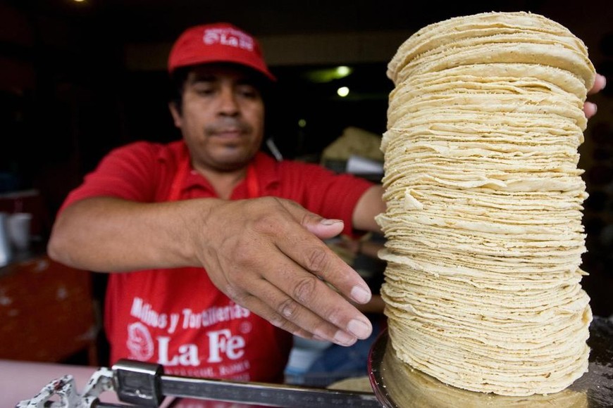 ELLITORAL_385125 |  Getty A stallholder weighs traditional corn tortillas in Mexico Cty, on June 18, 2008. Mexican president Felipe Calder?n announced an agreement with businessmen to freeze the prices of more than 150 nourishing basic products from now until December 31, in order to offset the world rise of food. AFP PHOTO/Ronaldo Schemidt   MORE IN IMAGE FORUM (Photo credit should read Ronaldo Schemidt/AFP/Getty Images)