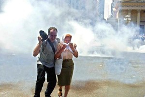 ELLITORAL_424470 |  Gentileza La imagen muestra la protección de un fotógrafo para con una Madre en medio de una nube de gases lacrimógenos.