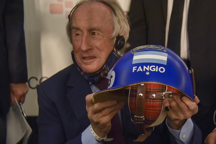 ELLITORAL_416937 |  Gentileza Sir Jackie Stewart junto a uno de los cascos de Fangio.