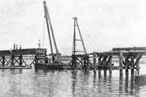 ELLITORAL_395522 |  Archivo El Litoral - Boletín de O.S.N. 1939 En 1903, el Gobernador Dr. Rodolfo Freyre, obtuvo el apoyo de Obras de Salubridad para construir una toma de agua en el Colastiné y trasladarla a través de cañerías. En la imagen, la colocación de los tramos centrales del puente acueducto en 1909.