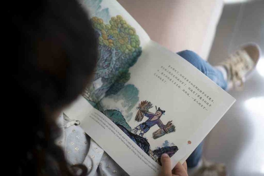ELLITORAL_416470 |  Xinhua Emma Jerez Leonardis, leyendo el cuento tradicional chino  El Hacha de Oro .