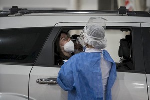 Xinhua/Martín Zabala (210406) -- BUENOS AIRES, 6 abril, 2021 (Xinhua) -- Una trabajadora de salud toma una muestra de hisopado nasal a una mujer a bordo de un automóvil para una prueba de detección de la enfermedad del nuevo coronavirus (COVID-19), en el centro vehicular de Costa Salguero, en la ciudad de Buenos Aires, Argentina, el 6 de abril de 2021. La segunda ola de contagios de la COVID-19 "ya es un hecho" en Argentina, por lo que las personas deben extremar los cuidados, advirtió el martes la ministra de Salud, Carla Vizzotti. (Xinhua/Martín Zabala) (mz) (oa) (ra) (vf)