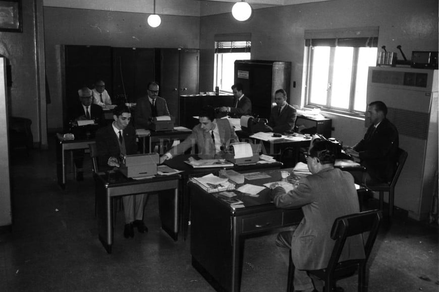 ELLITORAL_371666 |  Archivo El Litoral Vázquez Rossi (a la derecha, delante de la ventana) en la redacción de El Litoral, junto a Enrique Miguel Cruz, Arturo Lomello y otros.