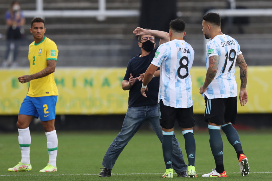 ELLITORAL_418425 |  Gentileza Soccer Football - World Cup - South American Qualifiers - Brazil v Argentina - Arena Corinthians, Sao Paulo, Brazil - September 5, 2021 Argentina's Marcos Acuna and Nicolas Otamendi are seen with a man on the pitch as play is interrupted after Brazilian health officials objected to the participation of three Argentine players they say broke quarantine rules REUTERS/Amanda Perobelli