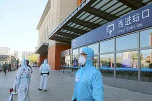 ELLITORAL_443580 |  Reuters Agentes de policía con trajes protectores custodian una entrada cerrada de una estación de tren en Jilin, China, en 2020.