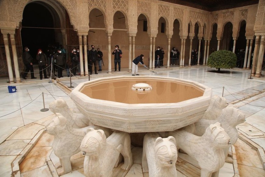 ELLITORAL_443898 |  EFE Una limpiadora en el Patio de Los Leones de la Alhambra de Granada, históricamente el monumento más visitado de España, ha reforzado las tareas de limpieza para actuar frente a la calima, que ha teñido de marrón algunas zonas del recinto tras la llegada de polvo en suspensión del norte de África a la Península.