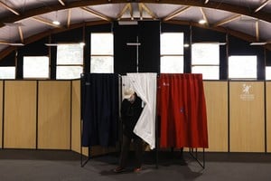 ELLITORAL_449542 |  Reuters Un hombre sale de una cabina de votación, con los colores de la bandera francesa, para votar en la primera ronda de las elecciones presidenciales francesas de 2022 en un colegio electoral en Le Touquet-Paris-Plage, Francia, el 10 de abril de 2022.