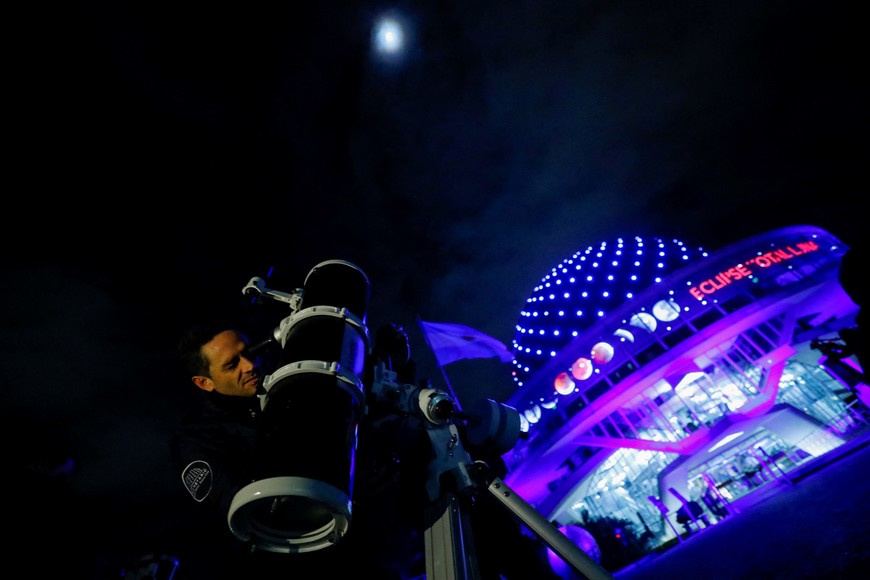 A man uses a telescope to monitor the moon ahead of a total lunar eclipse outside the Buenos Aires' planetarium in Buenos Aires, Argentina May 15, 2022. REUTERS/Agustin Marcarian