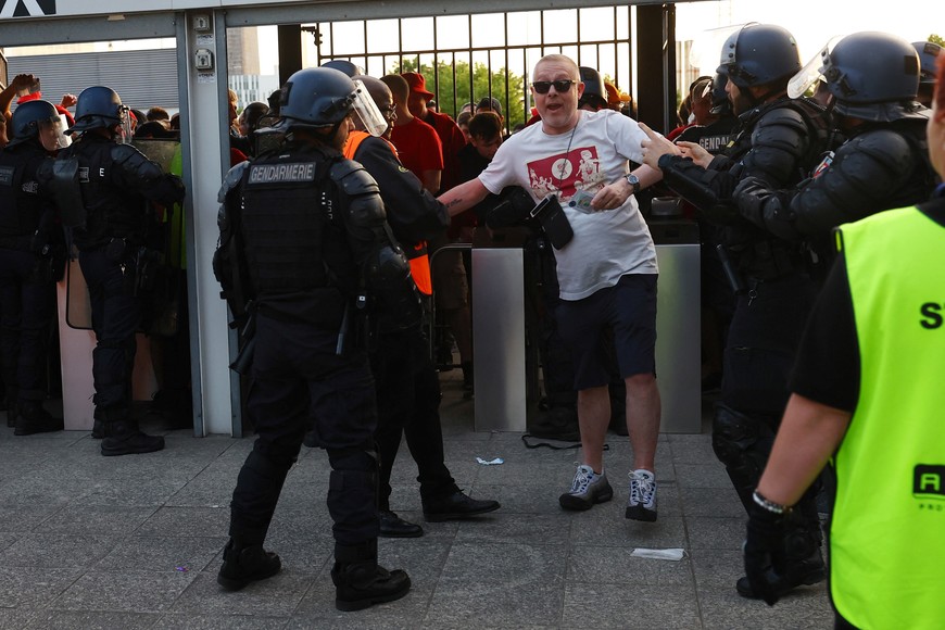 Soccer Football - Champions League Final - Liverpool v Real Madrid - Stade de France, Saint-Denis near Paris, France - May 28, 2022
Fans and police officers inside the stadium by the turnstiles as the match is delayed REUTERS/Kai Pfaffenbach