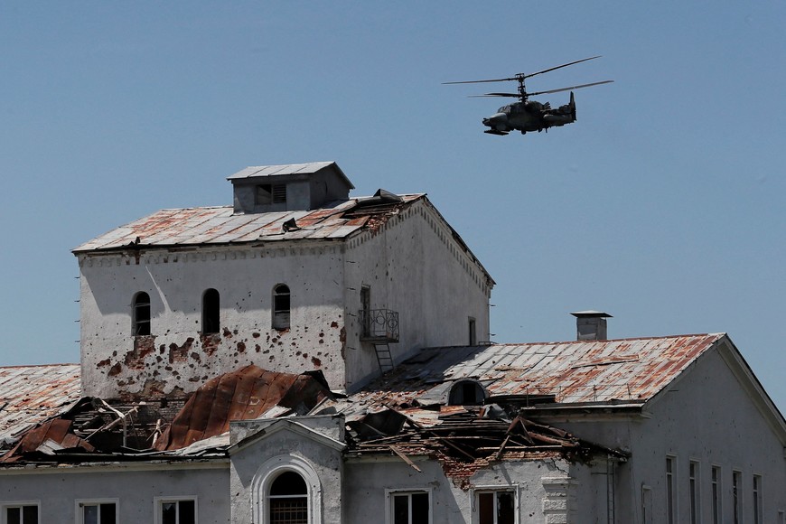 A Russian Ka-52 "Alligator" attack helicopter flies near a heavily damaged building during Ukraine-Russia conflict in the town of Popasna in the Luhansk Region, Ukraine June 2, 2022. REUTERS/Alexander Ermochenko