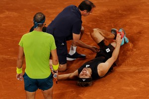 Tennis - French Open - Roland Garros, Paris, France - June 3, 2022
Germany's Alexander Zverev receives medical attention after sustaining an injury as Spain's Rafael Nadal looks on REUTERS/Gonzalo Fuentes