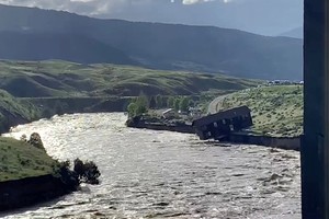 A house falls into the Yellowstone river due to flooding in Gardiner, Montana, U.S., June 13, 2022 in this screen grab obtained from a social media video. Angie Lilly/via REUTERS  THIS IMAGE HAS BEEN SUPPLIED BY A THIRD PARTY. MANDATORY CREDIT. NO RESALES. NO ARCHIVES.