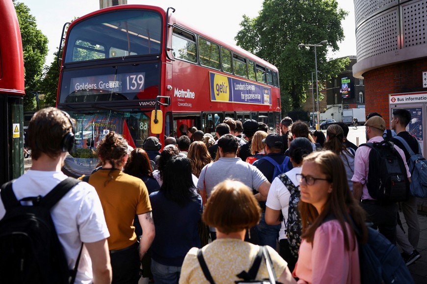 Passengers queue for a bus outside the Waterloo Station, on the first day of national rail strike in London, Britain, June 21, 2022. REUTERS/Henry Nicholls
