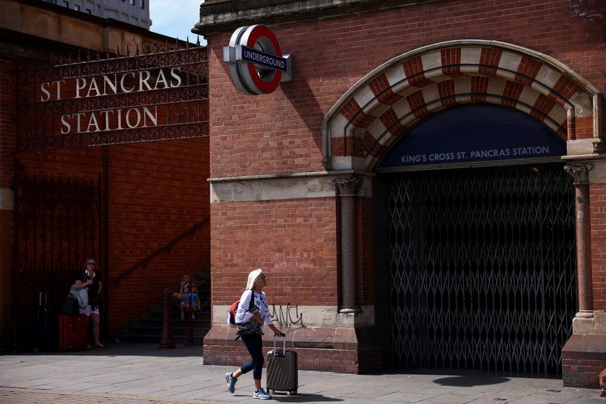 A woman with a luggage walks past a closed entrance to the underground train station on the first day of national rail strike in London, Britain, June 21, 2022. REUTERS/Henry Nicholls??