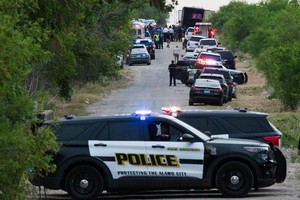 Law enforcement officers work at the scene where people were found dead inside a trailer truck in San Antonio, Texas, U.S. June 27, 2022. REUTERS/Kaylee Greenlee Beal