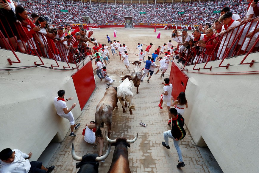 Revellers sprint during the running of the bulls at the San Fermin festival in Pamplona, Spain, July 14, 2022. REUTERS/Juan Medina