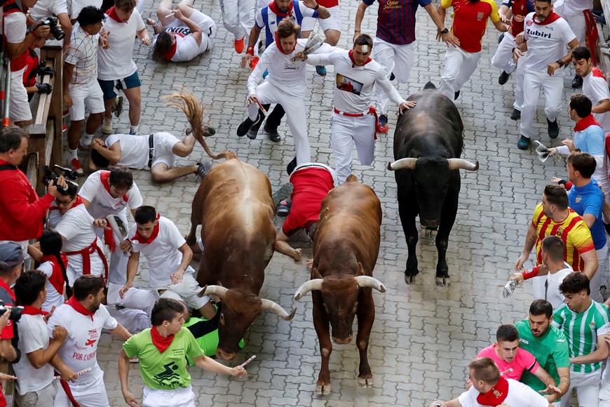Revellers sprint during the running of the bulls at the San Fermin festival in Pamplona, Spain, July 14, 2022. REUTERS/Juan Medina