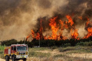 Los bomberos trataban el domingo de contener incendios forestales descontrolados