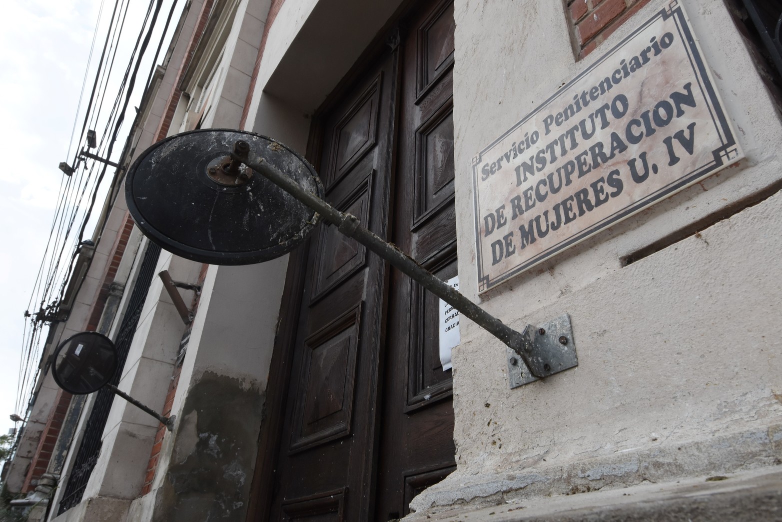 Un viejo cartel sobre calle Uruguay indica el ingreso al penal. Para poder entrar, cualquier visitante debe dejar su DNI, pertenencias de valor y es requisado. Crédito: Flavio Raina