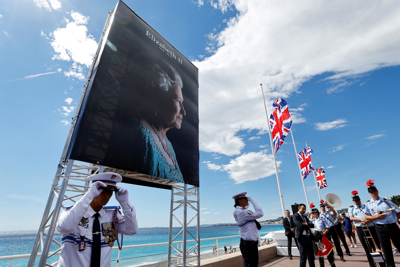 Las banderas Union Jack ondean a media asta cerca de un retrato de la reina Isabel en la Promenade des Anglais durante una ceremonia, tras el fallecimiento de la reina Isabel de Gran Bretaña, en Niza, Francia. Reuters/Eric Gaillard