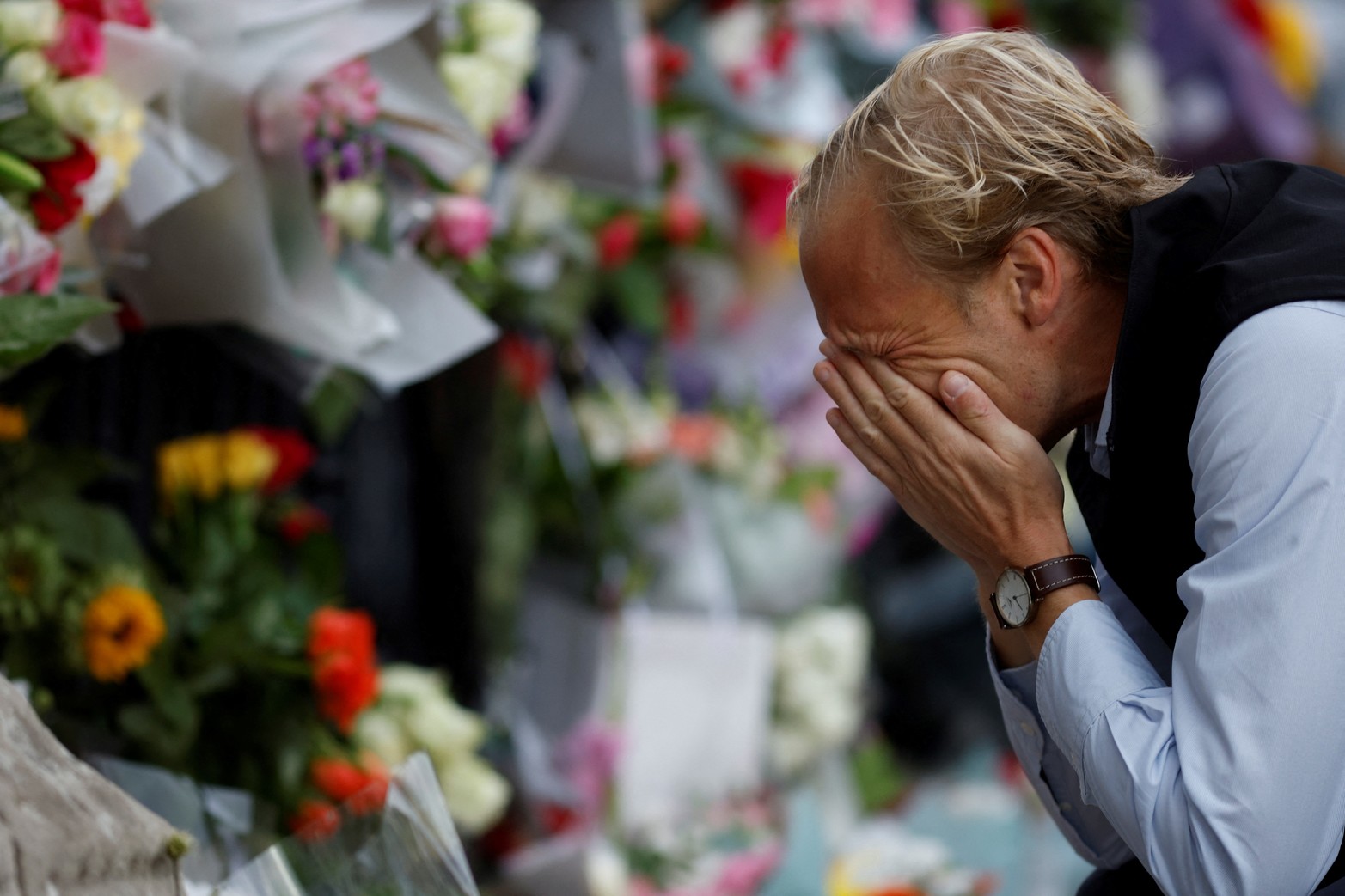 Un hombre reacciona cerca de los tributos florales colocados en el Palacio de Buckingham, tras el fallecimiento de la Reina Isabel, en Londres, Gran Bretaña. Reuters/John Sibley