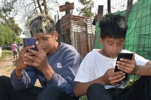 Conectados. Leonardo (16) y Ariel (13) no tienen celulares. Pero usan el de sus madres para acceder al mundo desde este rincón postergado de Santa Fe, gracias al internet gratuito.  Crédito: Flavio Raina.