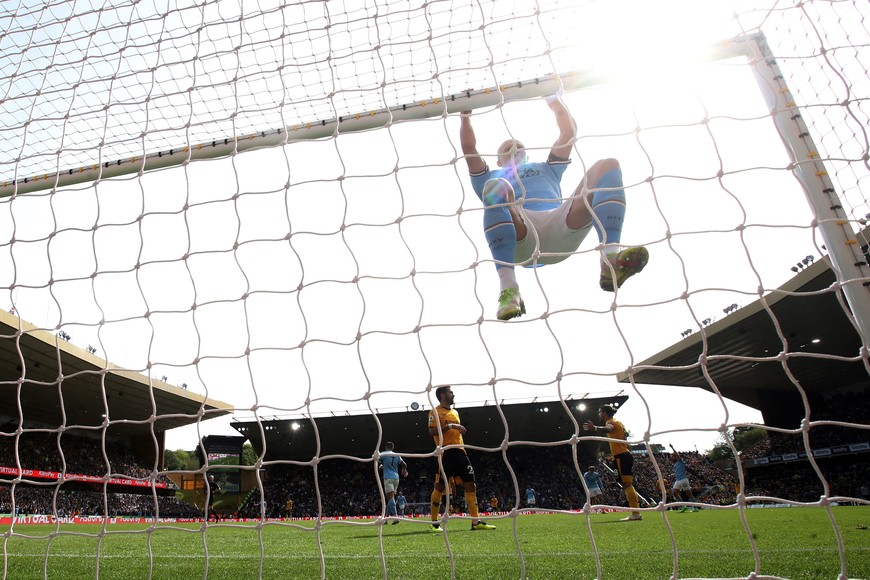 Soccer Football - Premier League - Wolverhampton Wanderers v Manchester City - Molineux Stadium, Wolverhampton, Britain - September 17, 2022
Manchester City's Erling Braut Haaland hangs off the crossbar Action Images via Reuters/Carl Recine EDITORIAL USE ONLY. No use with unauthorized audio, video, data, fixture lists, club/league logos or 'live' services. Online in-match use limited to 75 images, no video emulation. No use in betting, games or single club	/league/player publications.  Please contact your account representative for further details.