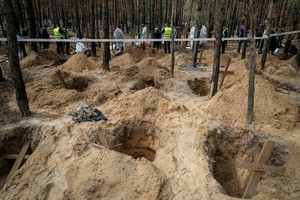 Police and experts work at a place of mass burial during an exhumation, as Russia's attack on Ukraine continues, in the town of Izium, recently liberated by Ukrainian Armed Forces, in Kharkiv region, Ukraine September 17, 2022.  REUTERS/Gleb Garanich     TPX IMAGES OF THE DAY