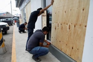 Los hombres suben a las ventanas cuando el huracán Roslyn se acerca a las zonas turísticas a lo largo de la costa del Pacífico de México, en San Blas, estado de Nayarit, México. Foto: Reuters