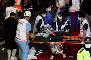 A man receives medical help at the scene where dozens of people were injured in a stampede during a Halloween festival in Seoul, South Korea, October 30, 2022. REUTERS/Kim Hong-ji REFILE - CORRECTING DATE