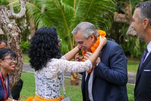 Alberto Fernández recibió el tradicional collar de flores tras bajar del avión. Crédito: Casa Rosada