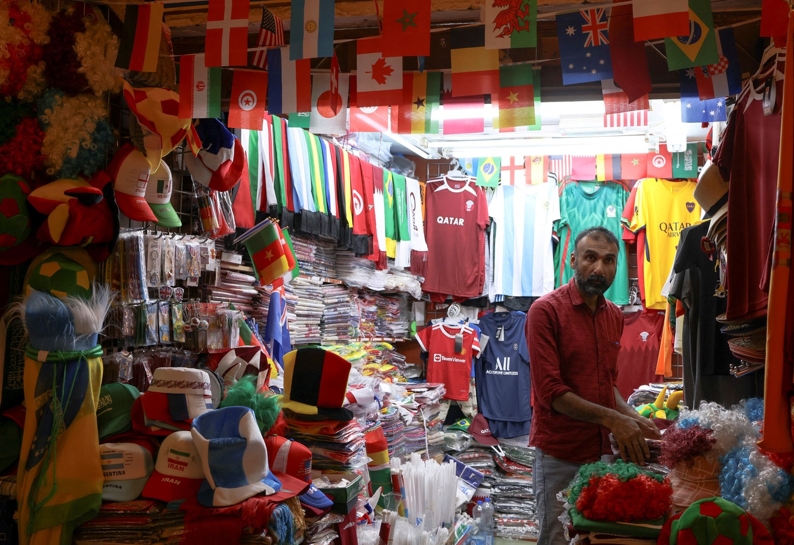 Un hombre espera a los clientes en una popular zona turística en Souq Waqif decorada con banderas internacionales, antes del torneo de fútbol de la Copa Mundial de la FIFA 2022 en Doha, Qatar.