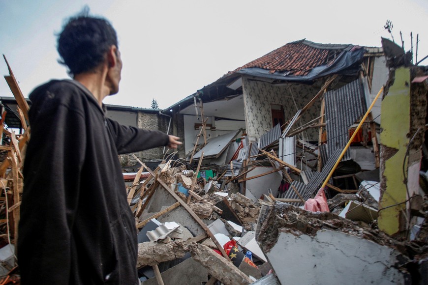 A local stands near houses damaged after earthquake hit in Cianjur, West Java province, Indonesia, November 21, 2022, in this photo taken by Antara Foto. Antara Foto/Yulius Satria Wijaya/ via REUTERS ATTENTION EDITORS - THIS IMAGE HAS BEEN SUPPLIED BY A THIRD PARTY. MANDATORY CREDIT. INDONESIA OUT. NO COMMERCIAL OR EDITORIAL SALES IN INDONESIA.
